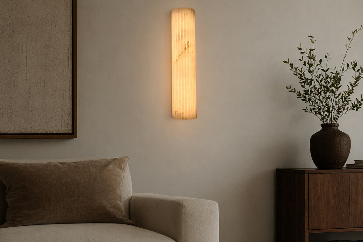 Modern Fluted Alabaster Wall Sconce casting warm light across an architectural living room wall