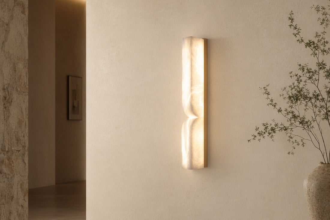 Modern Alabaster Linear Essence Wall Sconce in Natural Brass illuminated in a refined architectural hallway.
