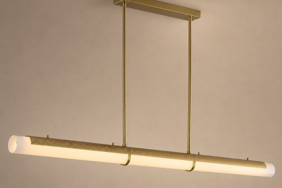 Natural brass-tone perforated linear LED pendant shown as a clean product view with warm acrylic glow.