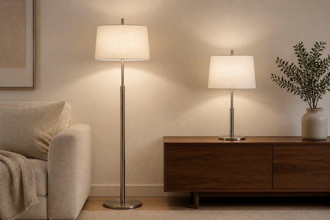 Matching satin-nickel floor and table lamps with off-white fabric shades in a layered living room.