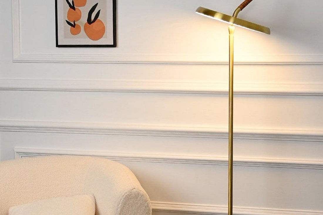 Gold ARDEN LUME travertine floor lamp beside a dark wood desk in a warm study.