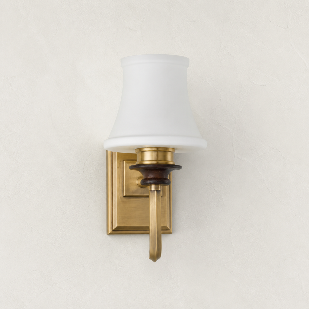 Kingswell opal glass and antique-brass wall sconce clean hero mounted flush to a plaster wall