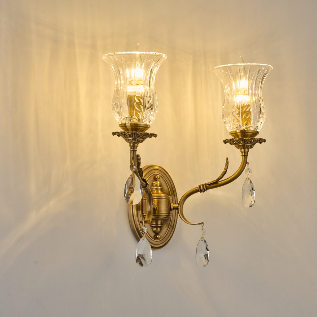 Vitrelaine two-light clear hurricane glass wall sconce mounted to a warm wall