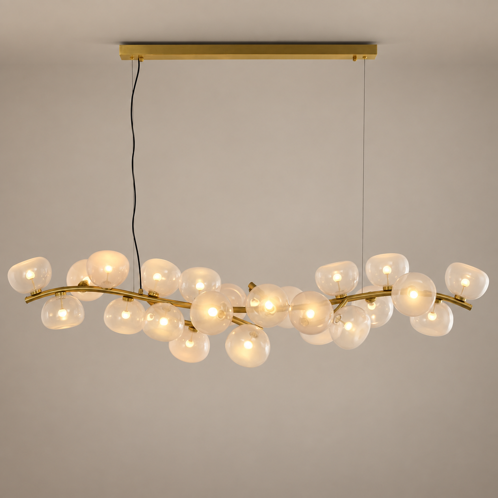 Blush glass 26-light linear chandelier in Natural Brass on a warm beige-gray product hero background