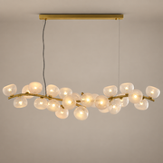 Blush glass 26-light linear chandelier in Natural Brass on a warm beige-gray product hero background