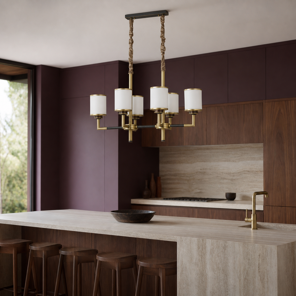 Unlit Orseline six-light linear chandelier placed off-center above a travertine island with a flush ceiling canopy