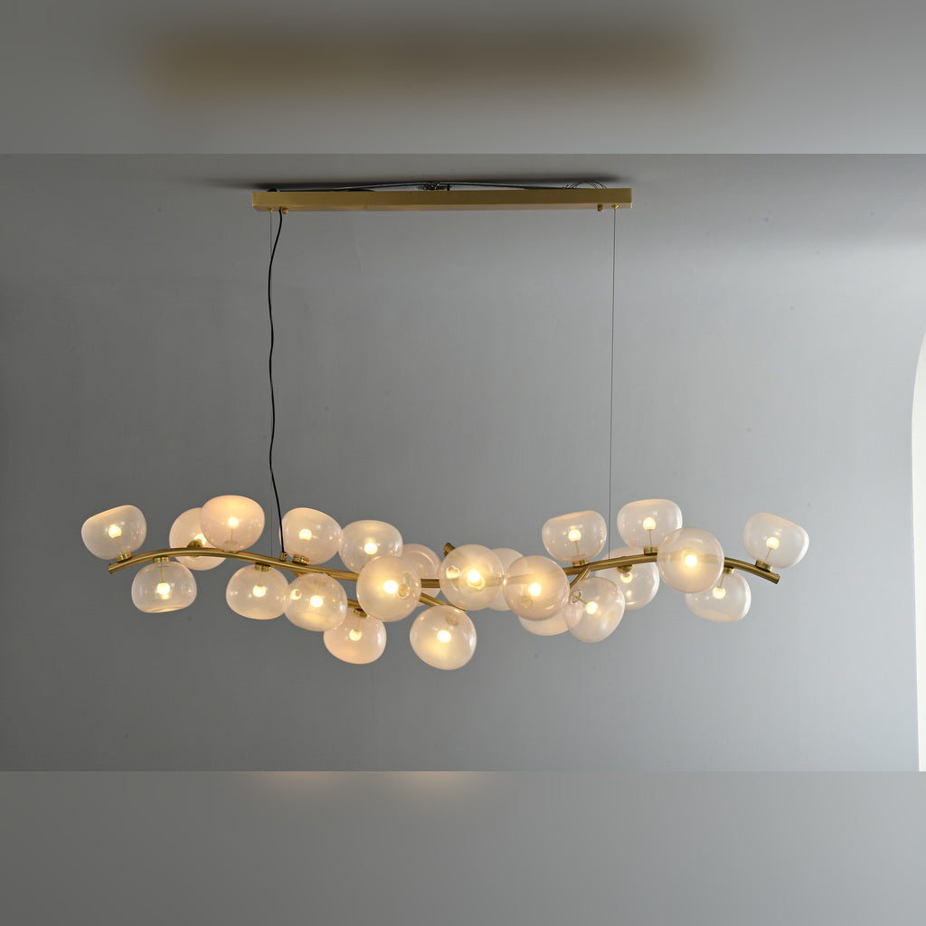 Clear glass 26-light linear chandelier in Natural Brass, illuminated front product view