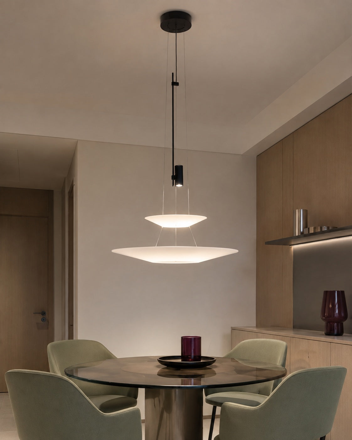 Two-tier layered acrylic disc pendant in a refined young city apartment dining nook