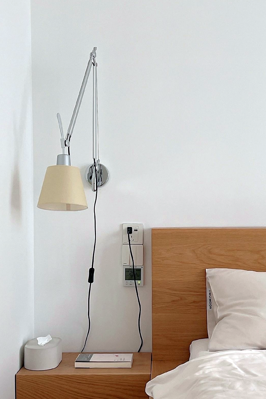 Bauhaus Adjustable Parchment Swing Arm Wall Light beside a bedside table