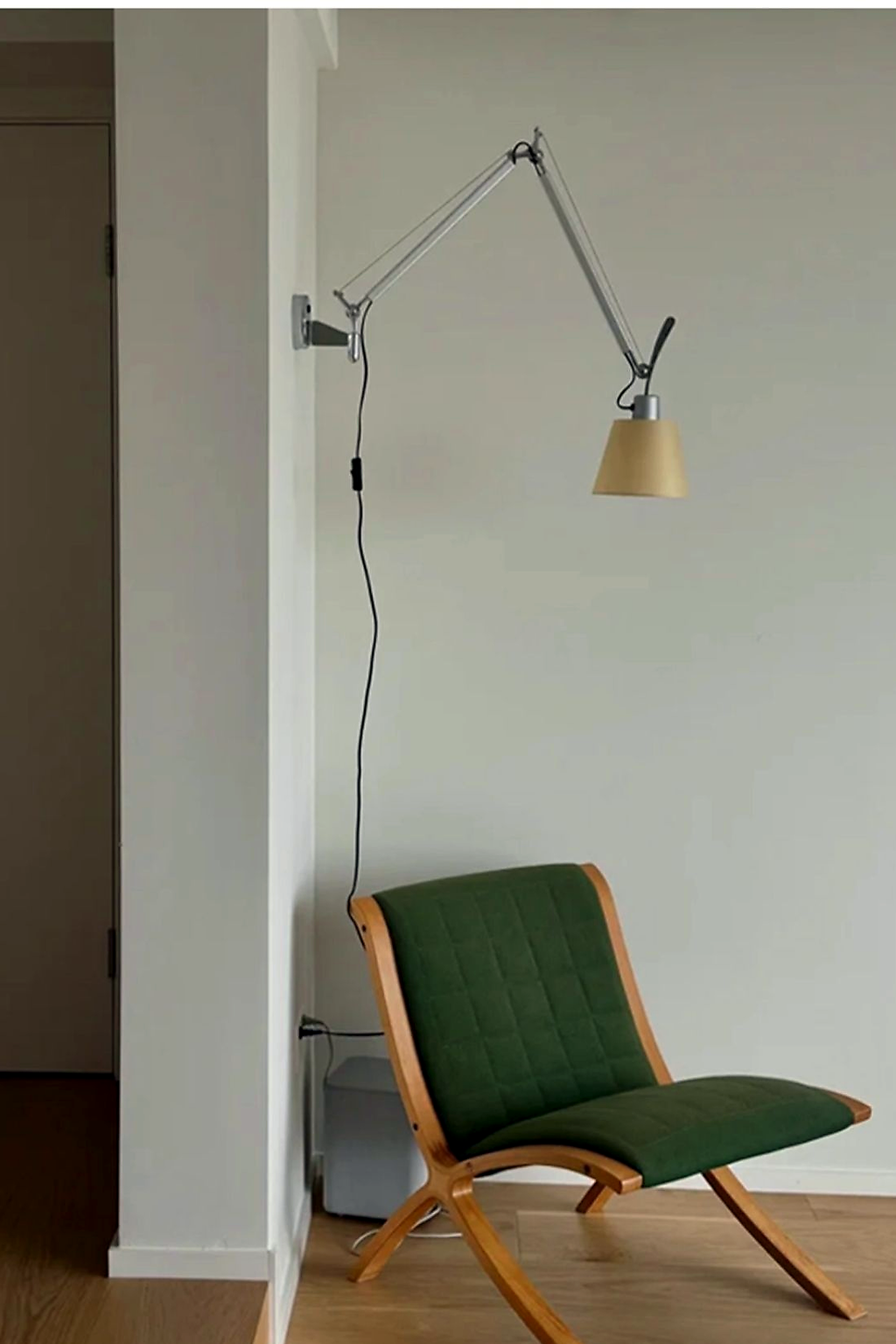 Bauhaus Adjustable Parchment Swing Arm Wall Light beside a reading chair