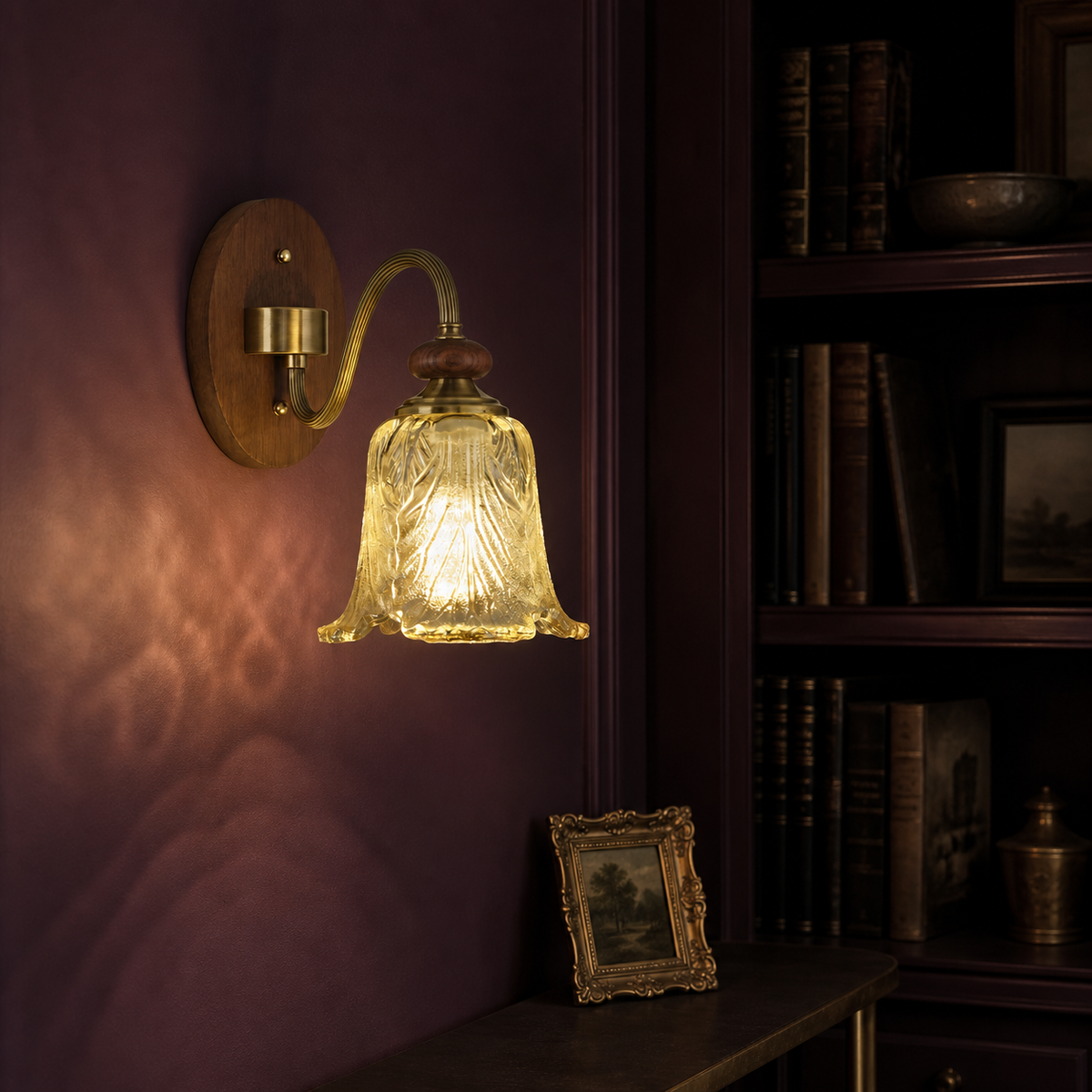 Sculpted leaf glass wall sconce on the left in an aubergine library niche