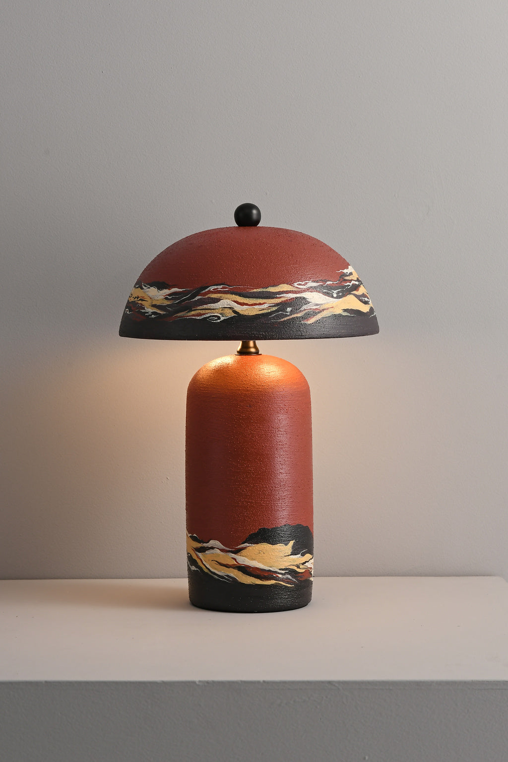 Sunset Red hand-painted ceramic table lamp lit in a real room