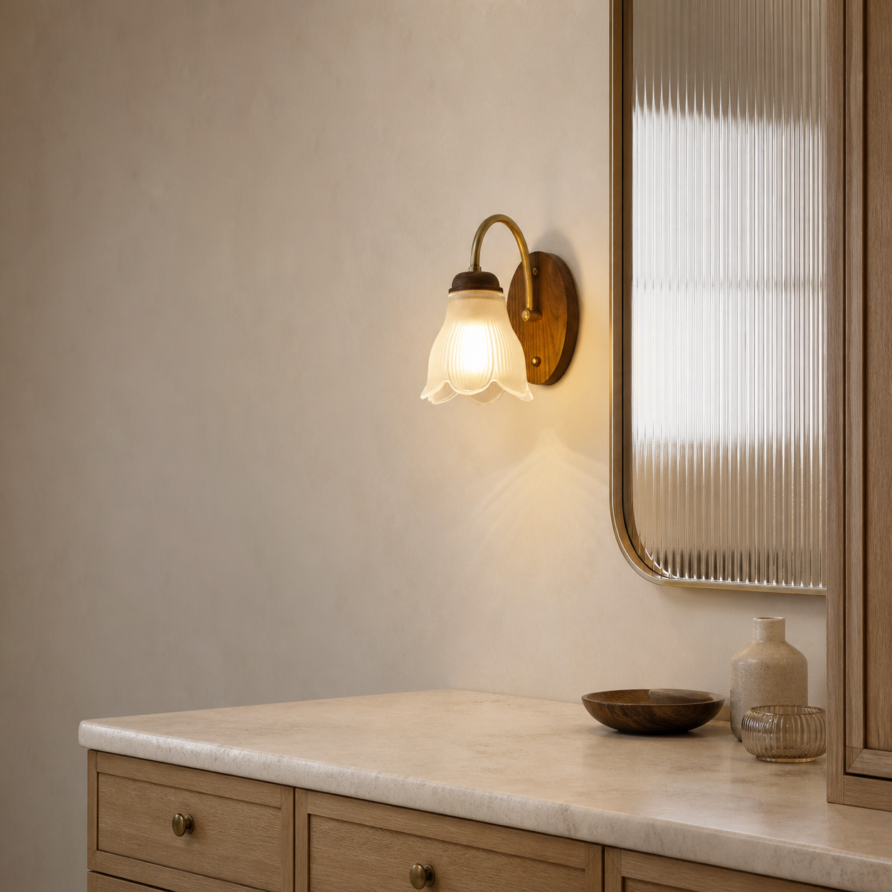 Ribbed bell glass wall sconce on the right in a dry light-oak vanity setting