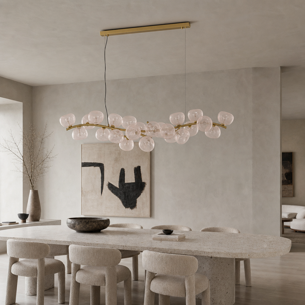 Blush glass 26-light linear chandelier with the lights off above a contemporary gallery table