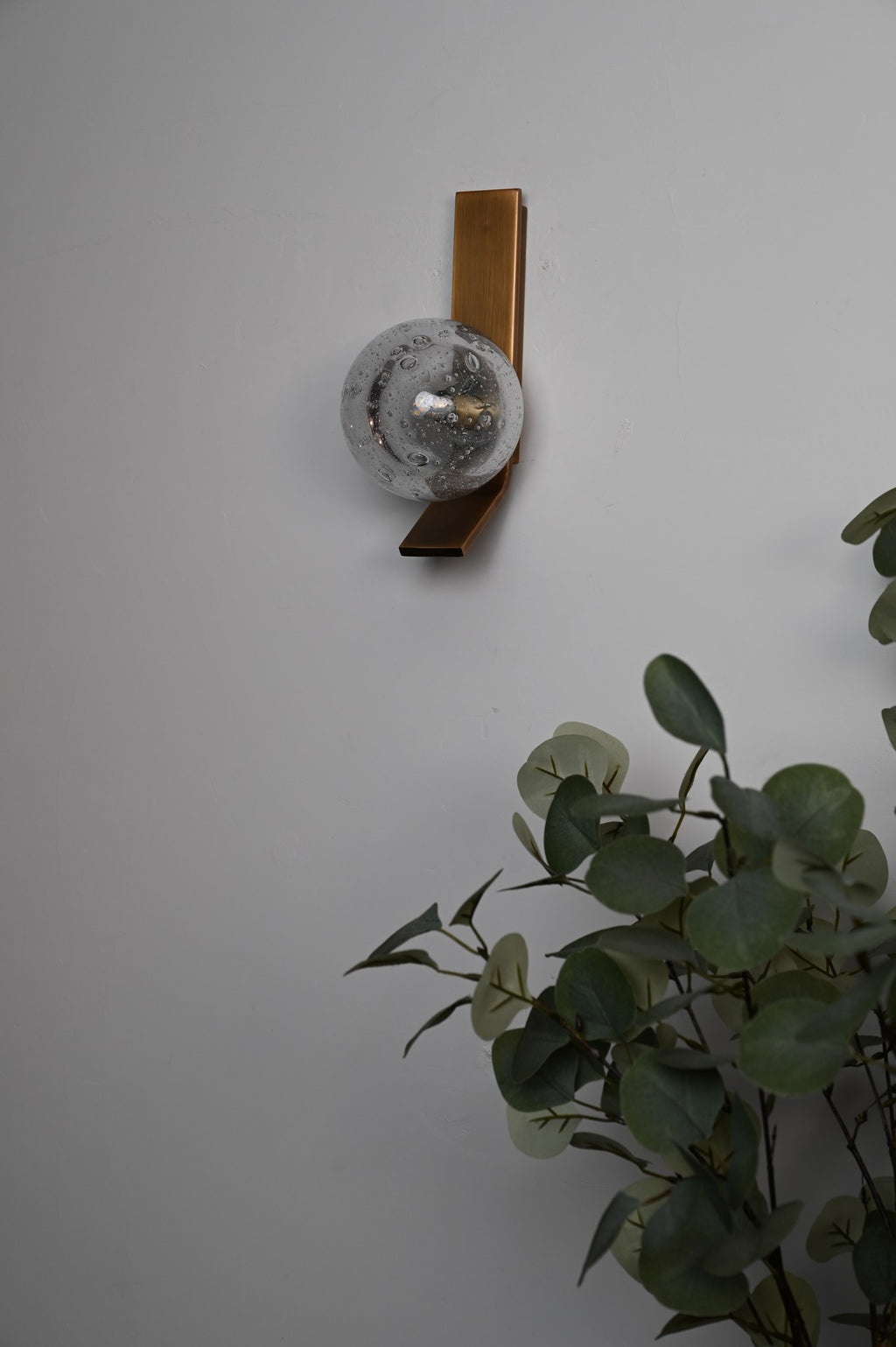 Modern Glass Globe Wall Sconce in Antique Brass - 06 06-real-shot-glass-globe-wall-sconce-lit-detail