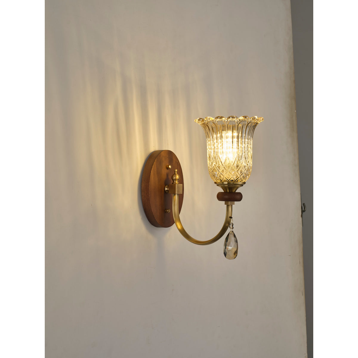 Supplier real three-quarter product photograph of the ribbed tulip glass wall sconce illuminated