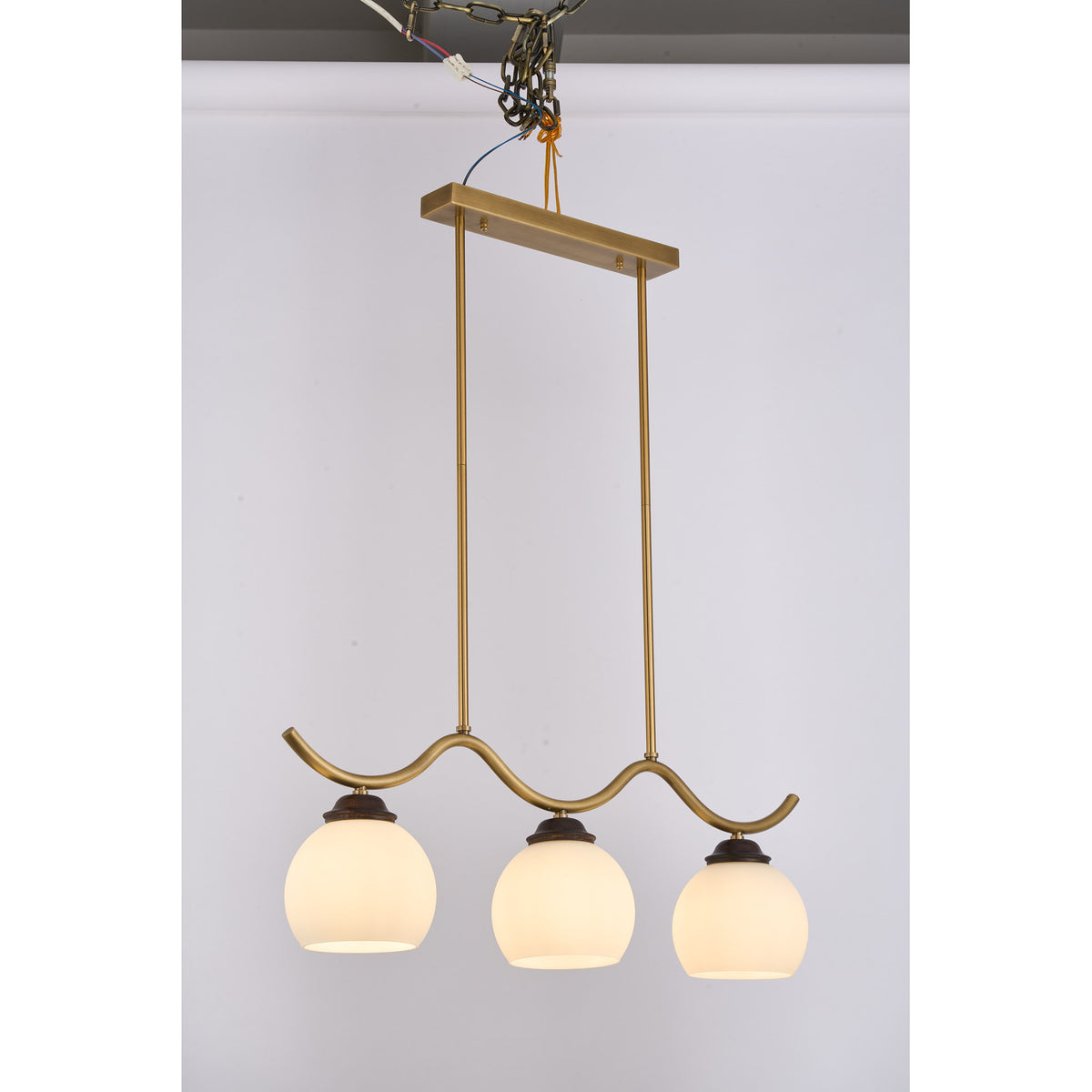 Supplier real photograph of the Ondervale three-light linear chandelier complete lit angled view