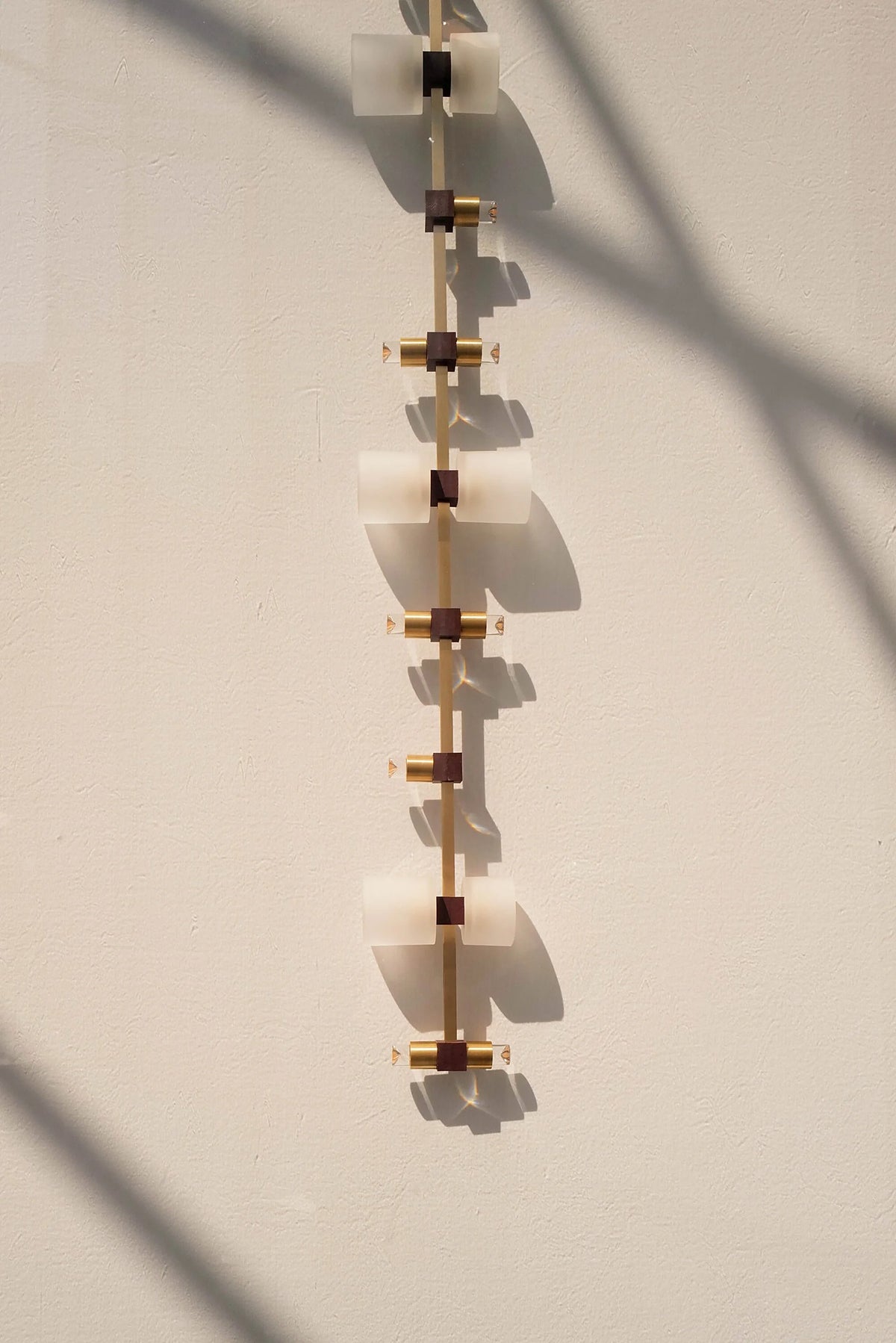 Royal vertical pendant complete installation shown against a pale architectural wall