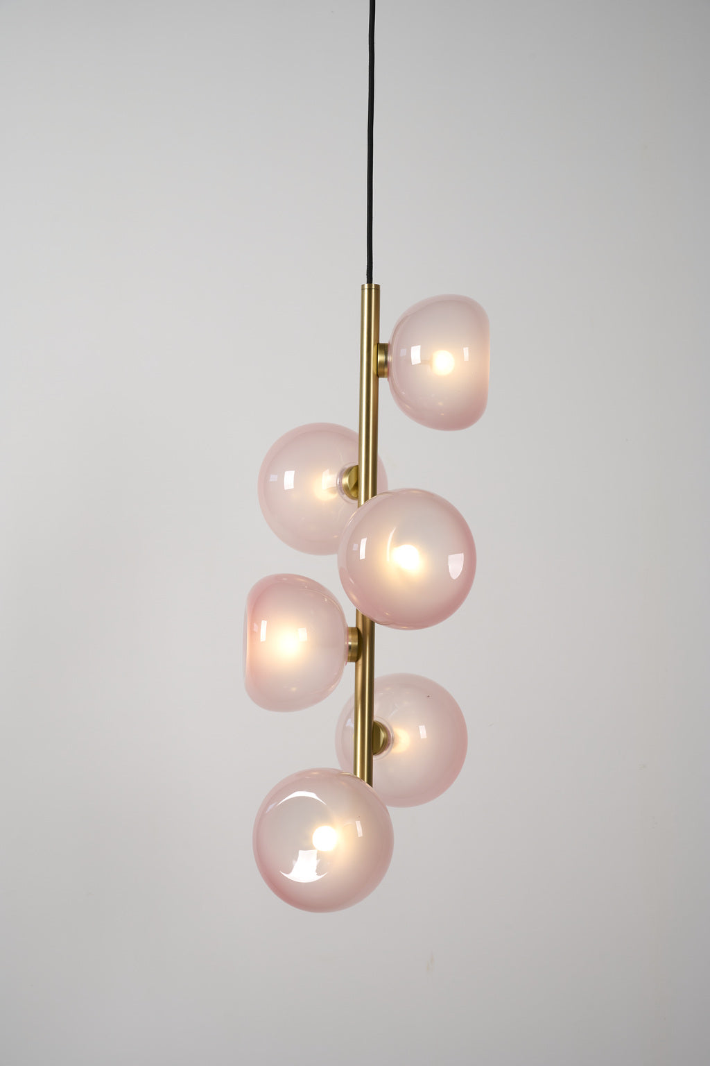 Blush glass six-light vertical pendant in Natural Brass, illuminated product view