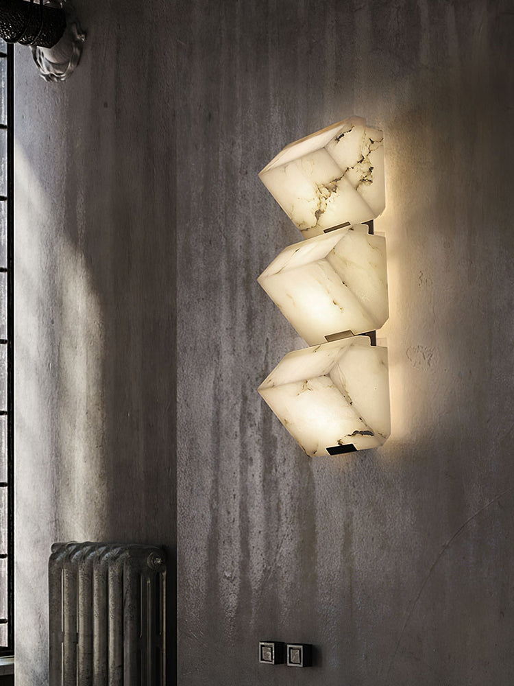 Three Modern Alabaster Geometric Wall Sconces installed vertically on a dark wall
