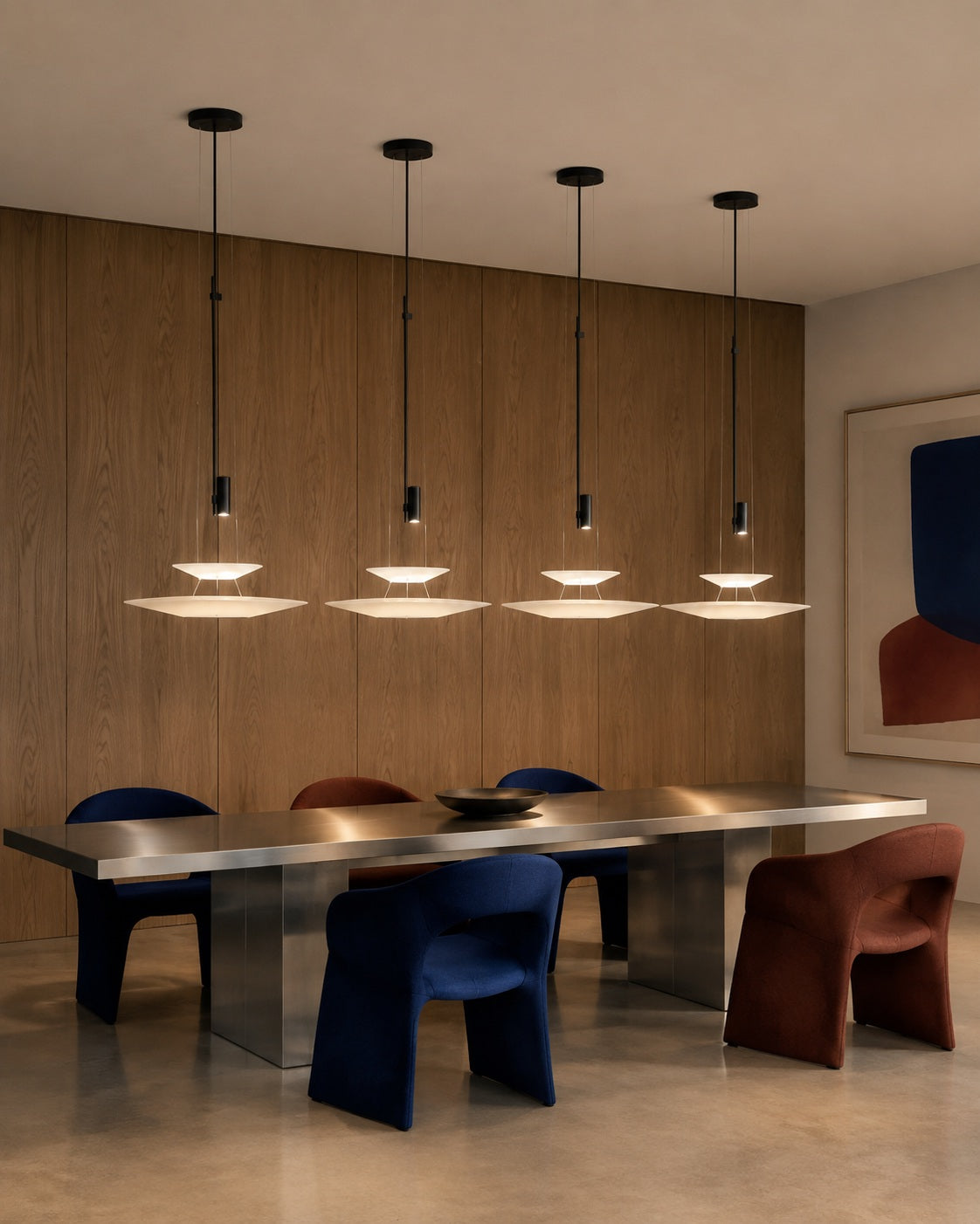 Four two-tier layered acrylic disc pendants with safe clearance above a long dining table