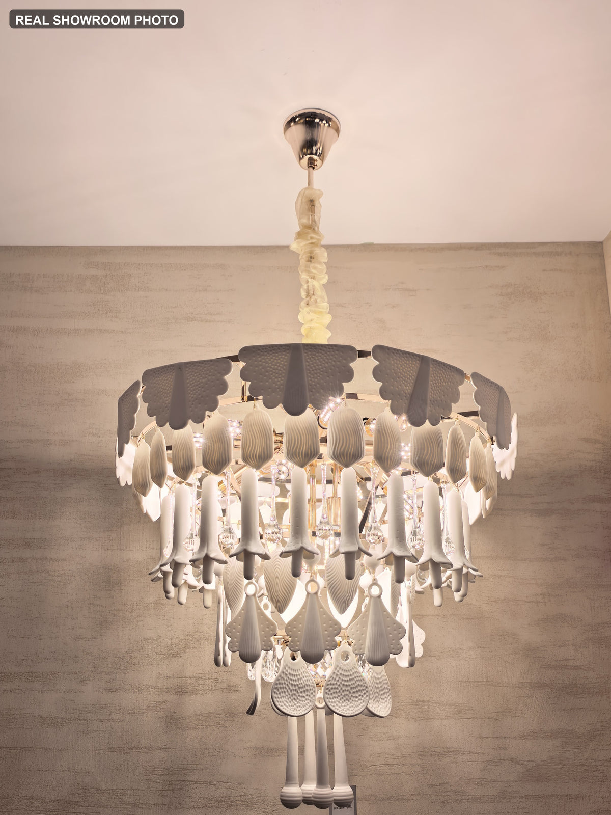 Real showroom photo — Muguetelle ivory ceramic chandelier alternate installed angle