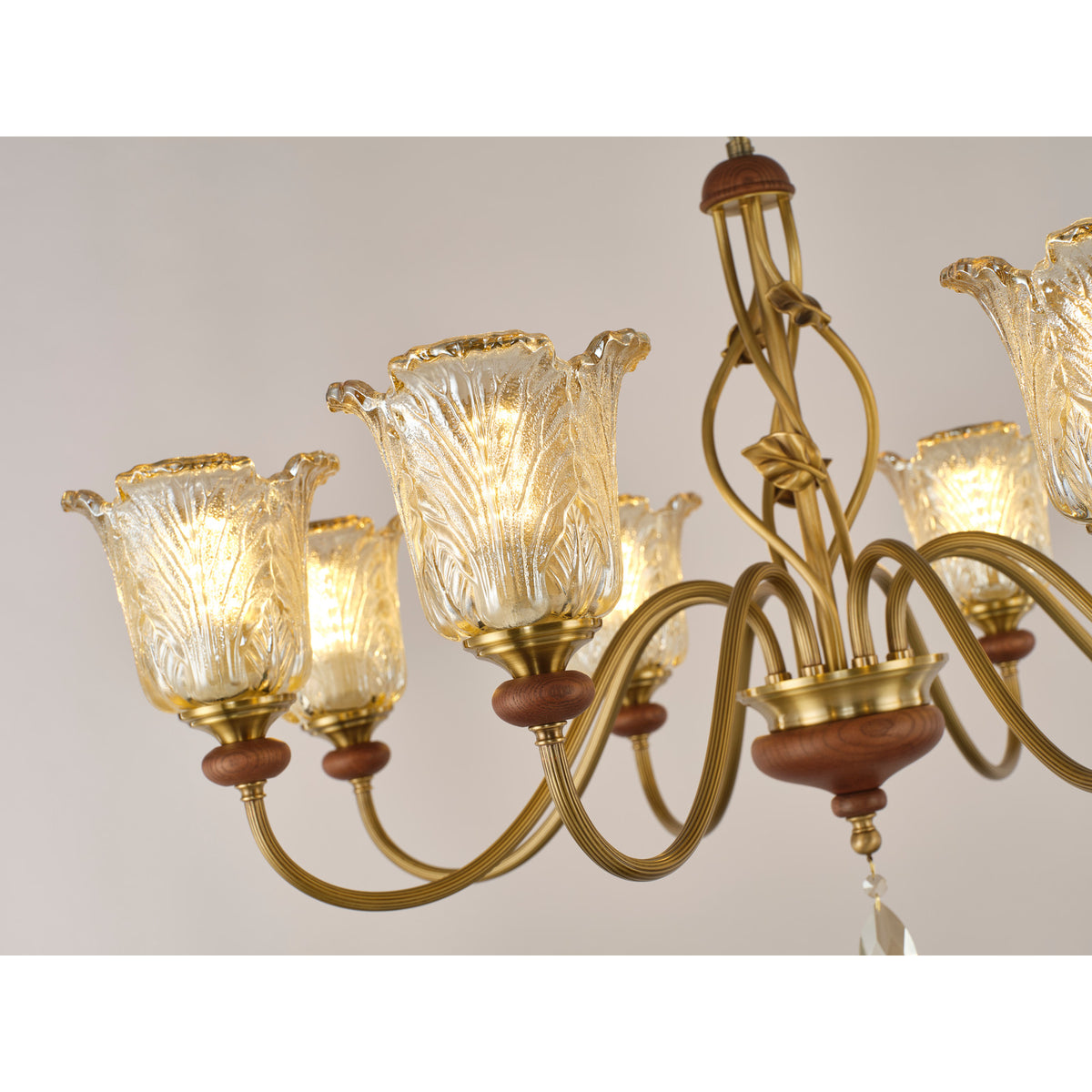 Real chandelier detail showing the sculpted leaf glass and looping arm