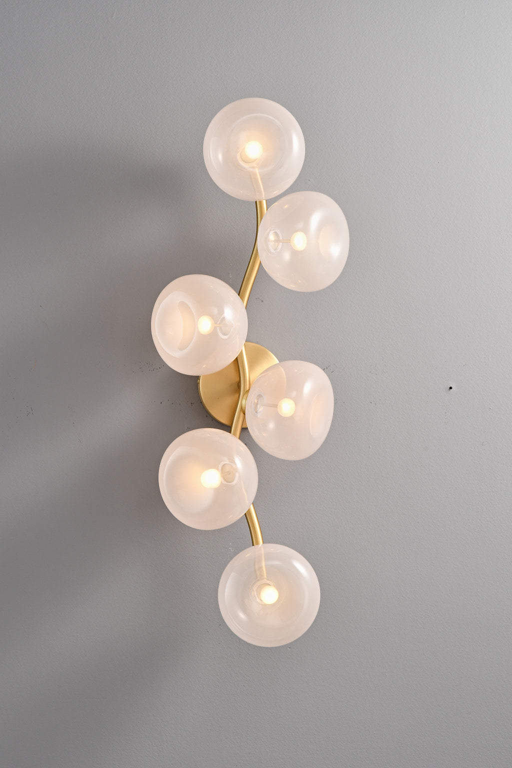 Modern Glass Globe Branch Wall Sconce in Natural Brass - 6 shades pink glass, lights on front view