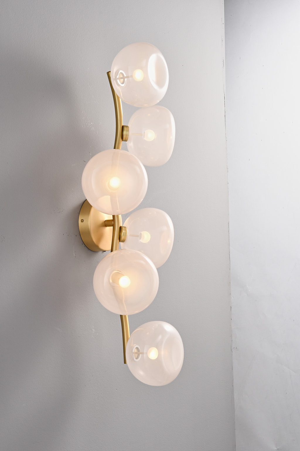 Modern Glass Globe Branch Wall Sconce in Natural Brass - 6 shades pink glass, lights on side view