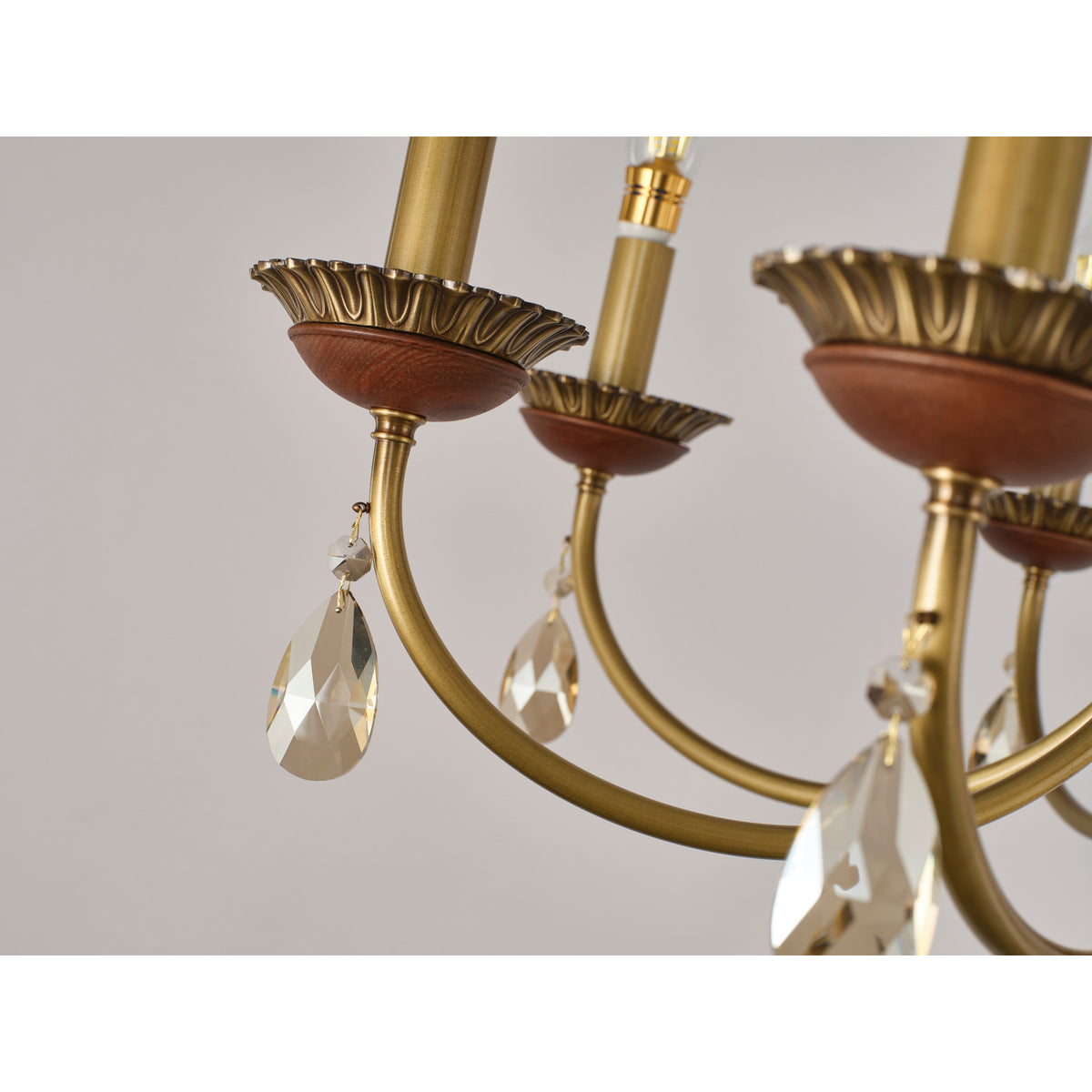 Real chandelier detail showing the ash-wood cup, leaf bobeche and faceted crystal pendant