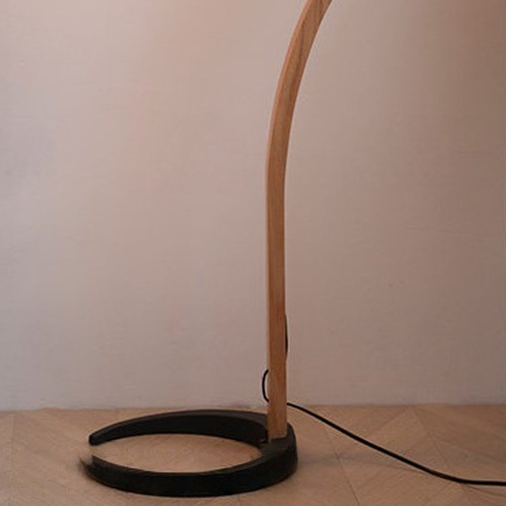 Sculptural Wood Floor Lamp — real black crescent base and floor-cord detail
