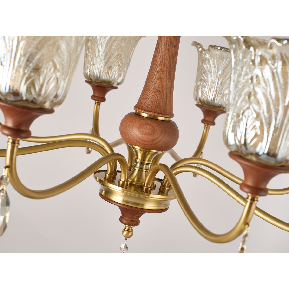 Real Aurelia chandelier detail showing the looping brass arm and crystal drop