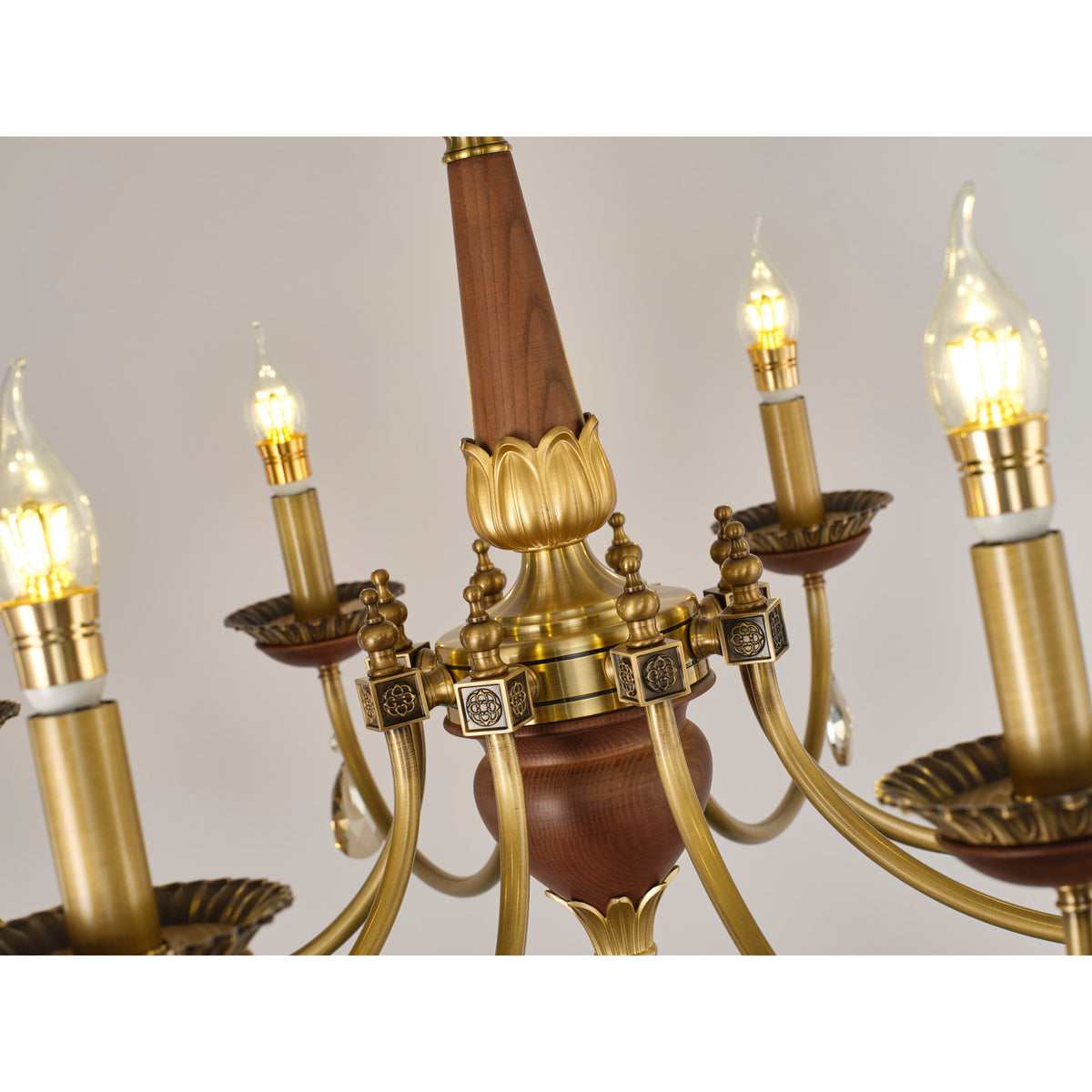 Real chandelier detail showing the ash-wood spindle, lotus collar and square floral hub blocks