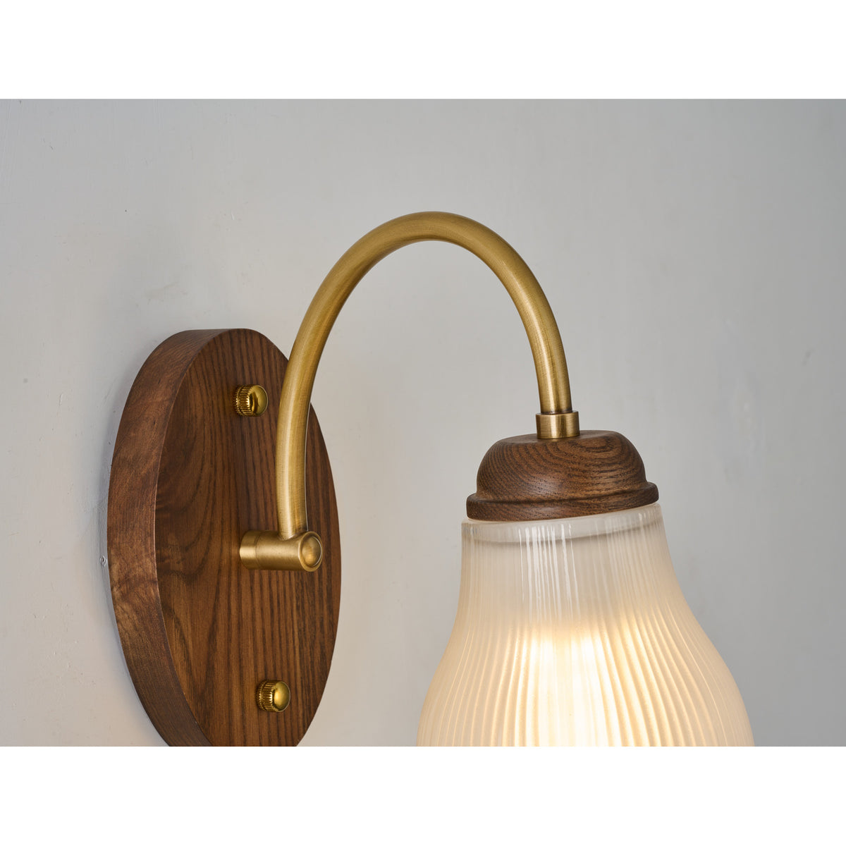 Supplier real wall sconce detail showing the antique brass-toned arm and wood collar