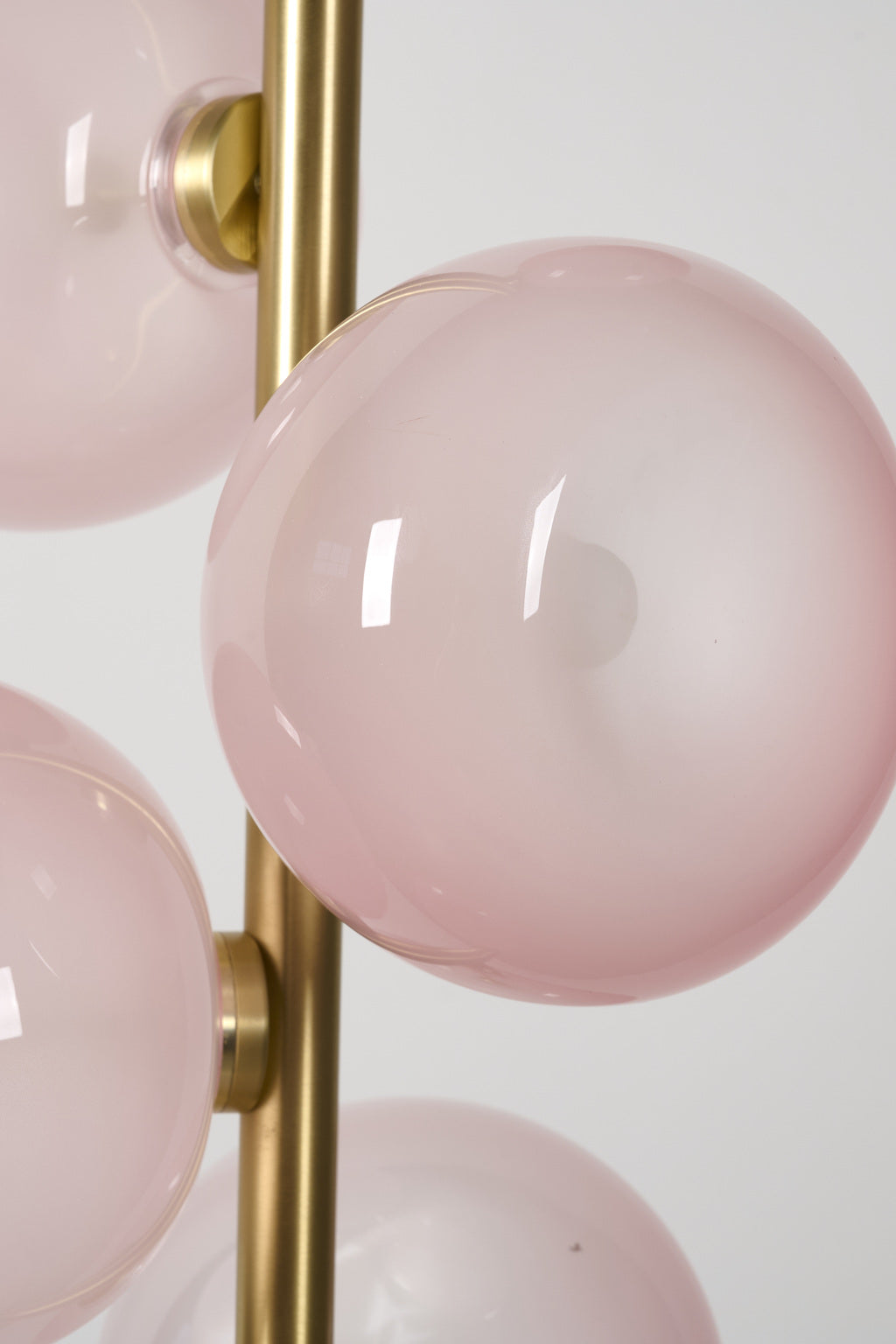 Blush glass globe and Natural Brass branch detail on the six-light pendant