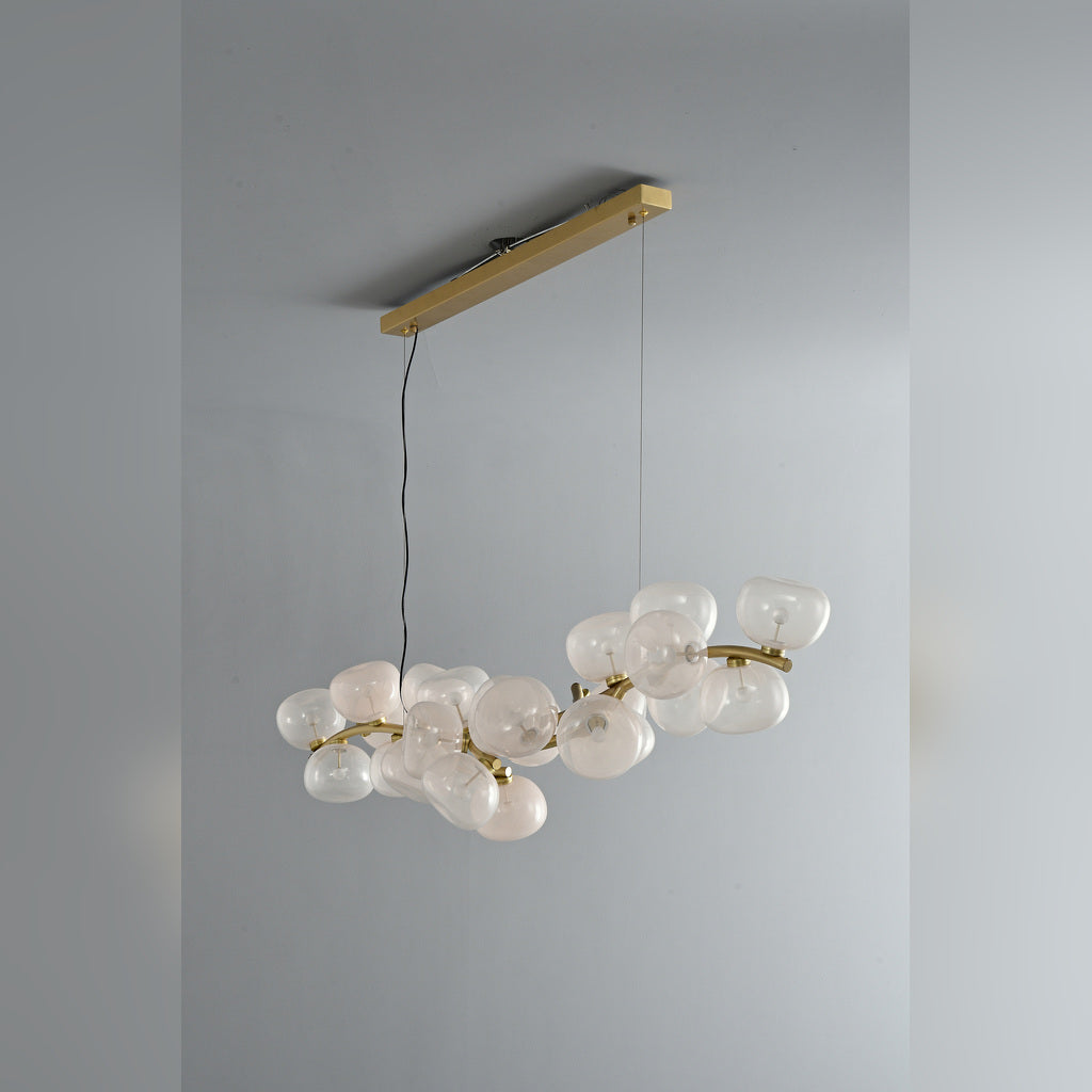 Clear glass 26-light linear chandelier in Natural Brass, unlit three-quarter product view