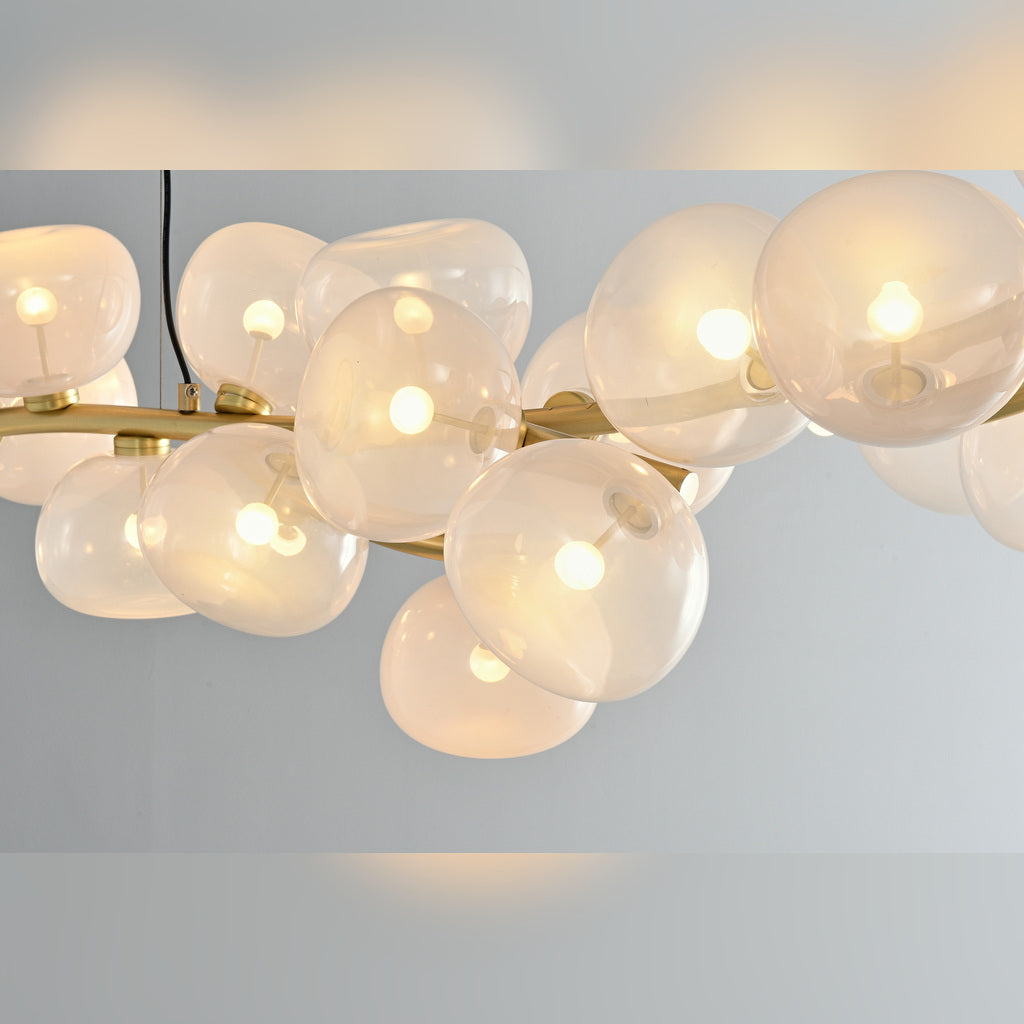 Illuminated clear glass shade and Natural Brass branch detail on the 26-light linear chandelier