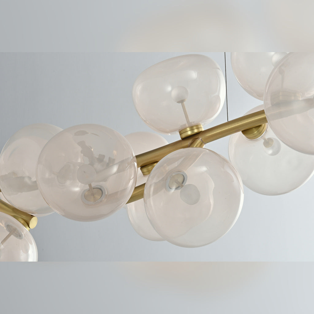 Clear glass shade and Natural Brass branch detail on the 26-light linear chandelier with the lights off