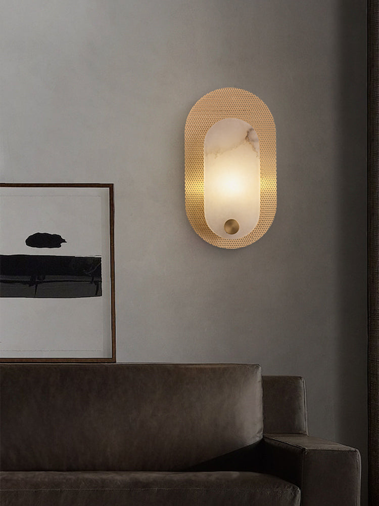 Modern Alabaster Oval Wall Sconce in Matte Gold illuminated in a living room