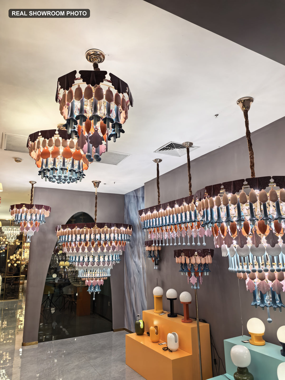 Real showroom photo — Muguetelle chandelier and wall sconce series display