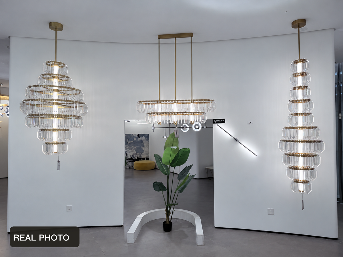 Arquelle Round Antique Brass Acrylic Tiered Chandelier showroom group real product photo with foreground display removed — REAL PHOTO · CDE cleaned foreground fixture and tag v1 2026-09-23