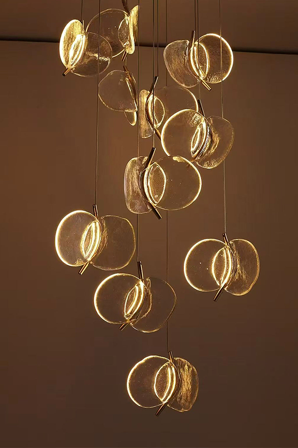 Warm-lit clear glass petal cascade chandelier close view