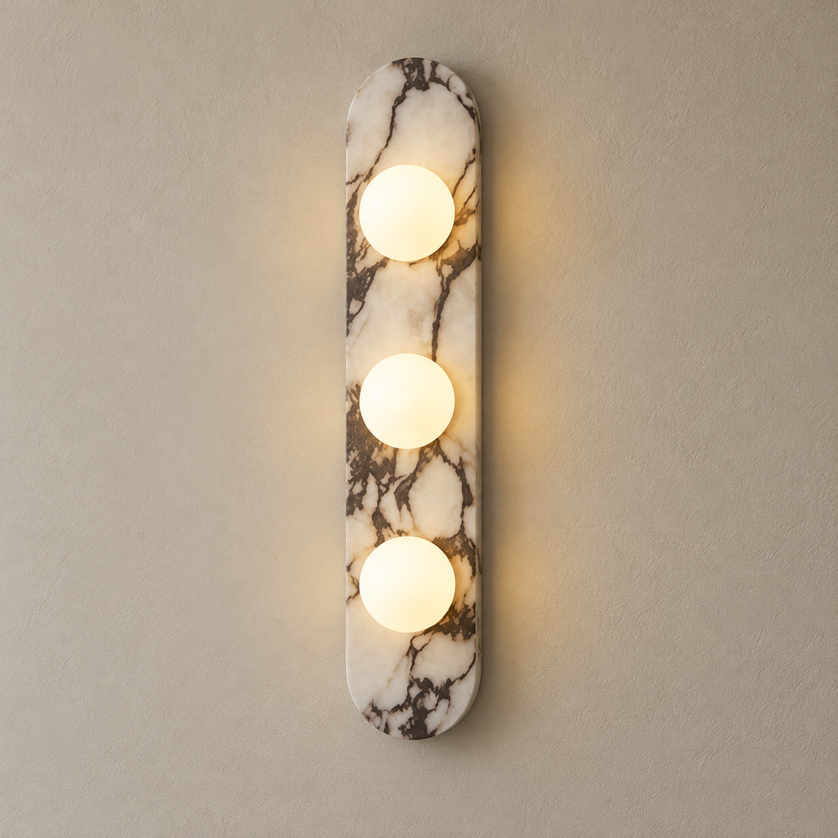 Modulo Marble Globe Wall Sconce on a warm greige background; White marble, three-globe configuration