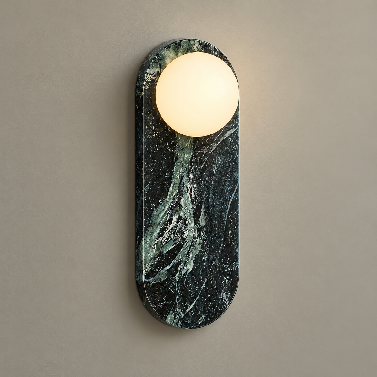 Lucie Oval Marble Wall Sconce on a warm greige background; Dark green marble capsule, single upper globe