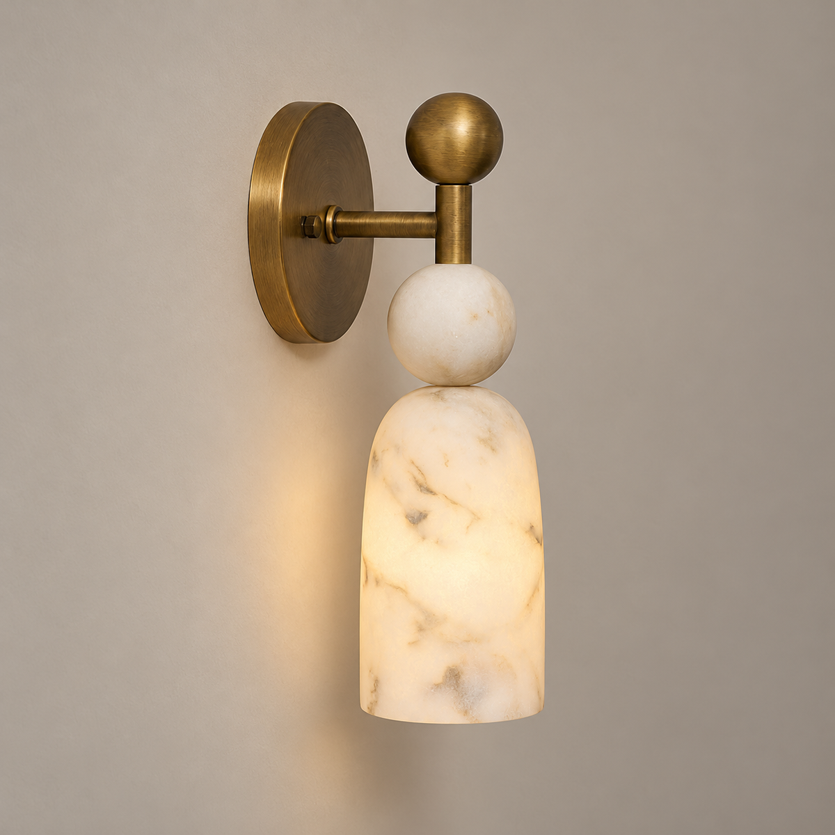 Flume Art Deco Alabaster Wall Sconce on a warm greige background; White alabaster and weathered brass, 31cm one-stone-ball configuration