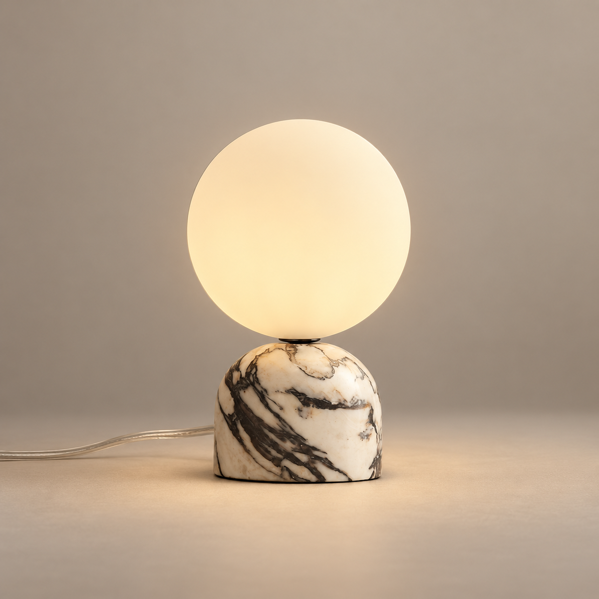Aalia Mid-Century Marble Table Lamp on a warm greige background; Purple-veined cream marble table base; warm opal globe