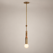 Allia Marble Pendant Light on a warm greige background; Single head; antique brass rod; four brown marble beads