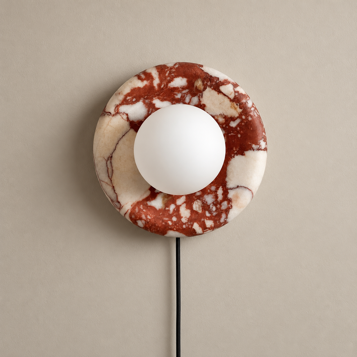 Orli Red Marble Plug-In Globe Wall Sconce on a warm greige background; Red marble plug-in wall disc; white globe off