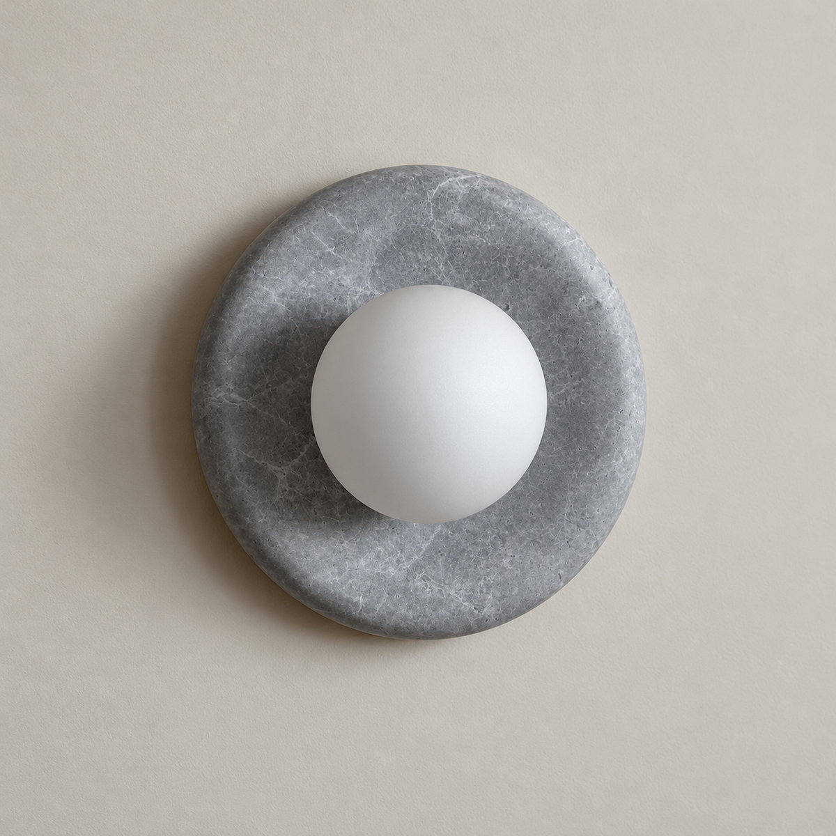 Orli Grey Marble Globe Wall Sconce on a warm greige background; Grey marble disc; white globe off