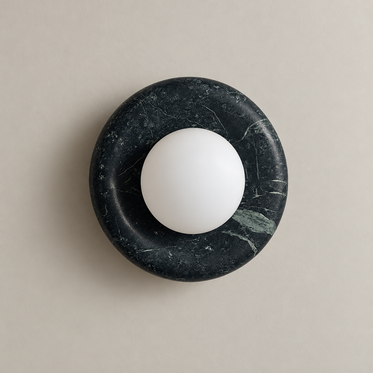 Orli Dark Green Marble Globe Wall Sconce on a warm greige background; Dark forest green marble circular plate; white opal globe